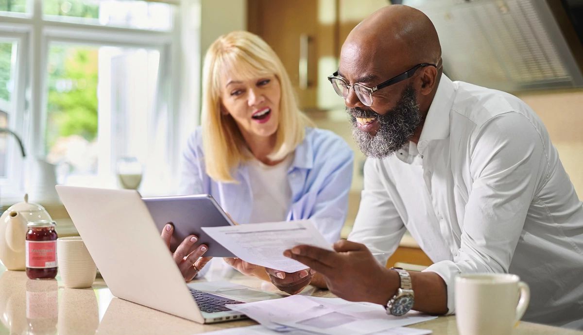 Couple in kitchen with tax forms in hand