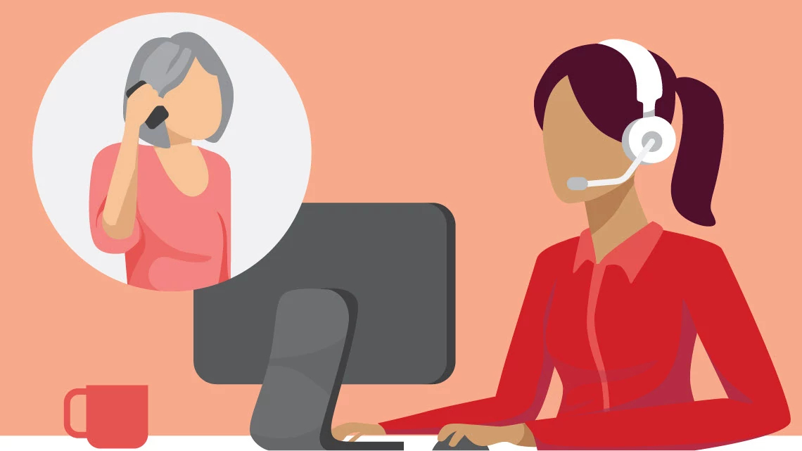 AARP Fraud Watch Network Helpline woman on phone talking to a woman in front of computer with headphones