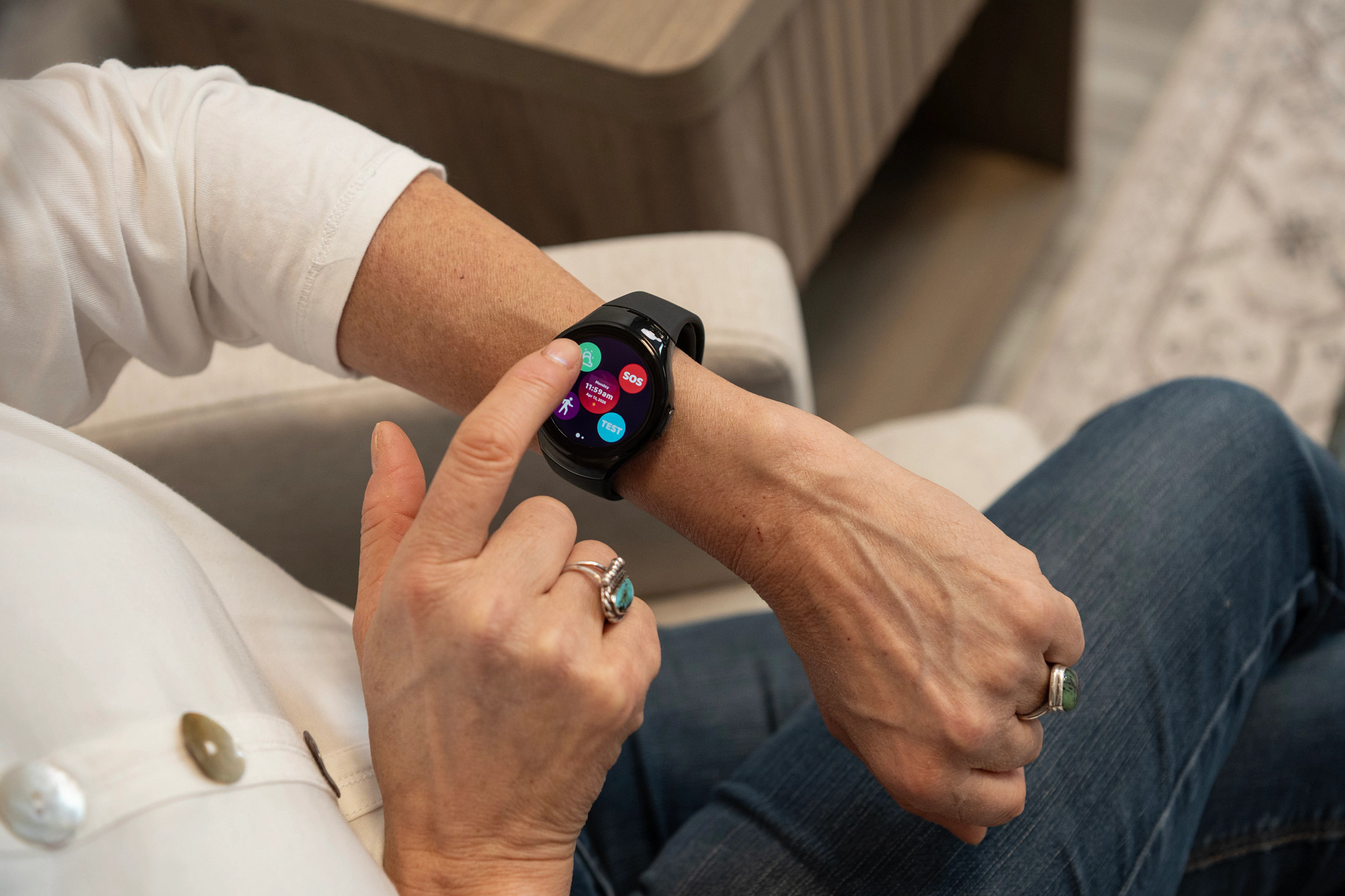 Woman wears a medical alert smartwatch and swipes the touchscreen