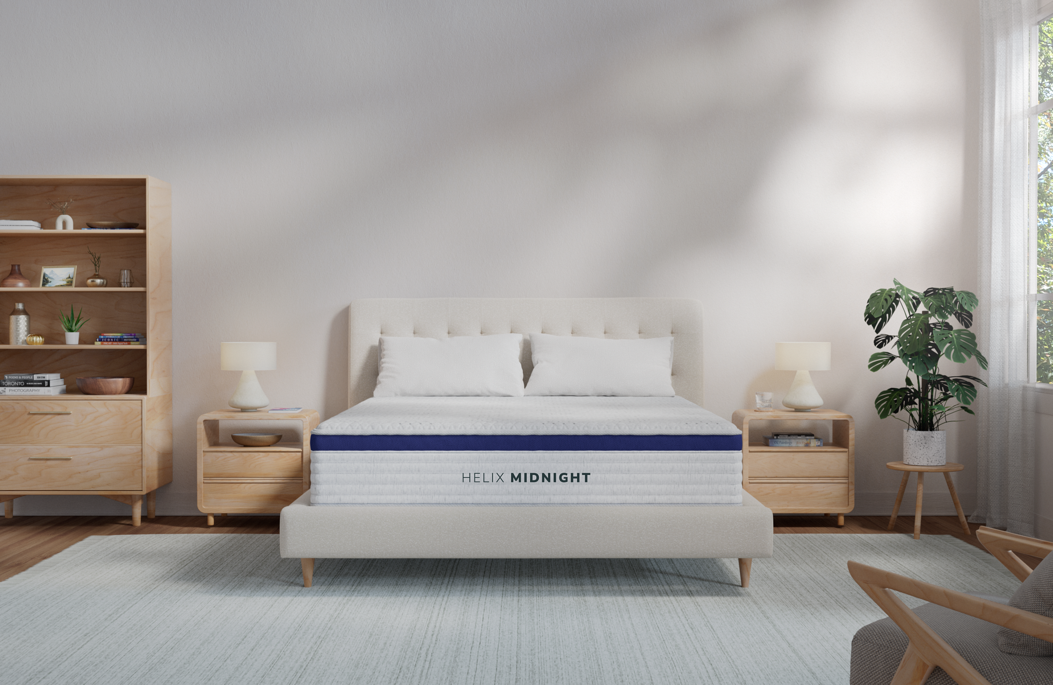 The Helix Midnight sits on a beige bed frame staged in a basic white room with a neutral rug and light wood nightstands