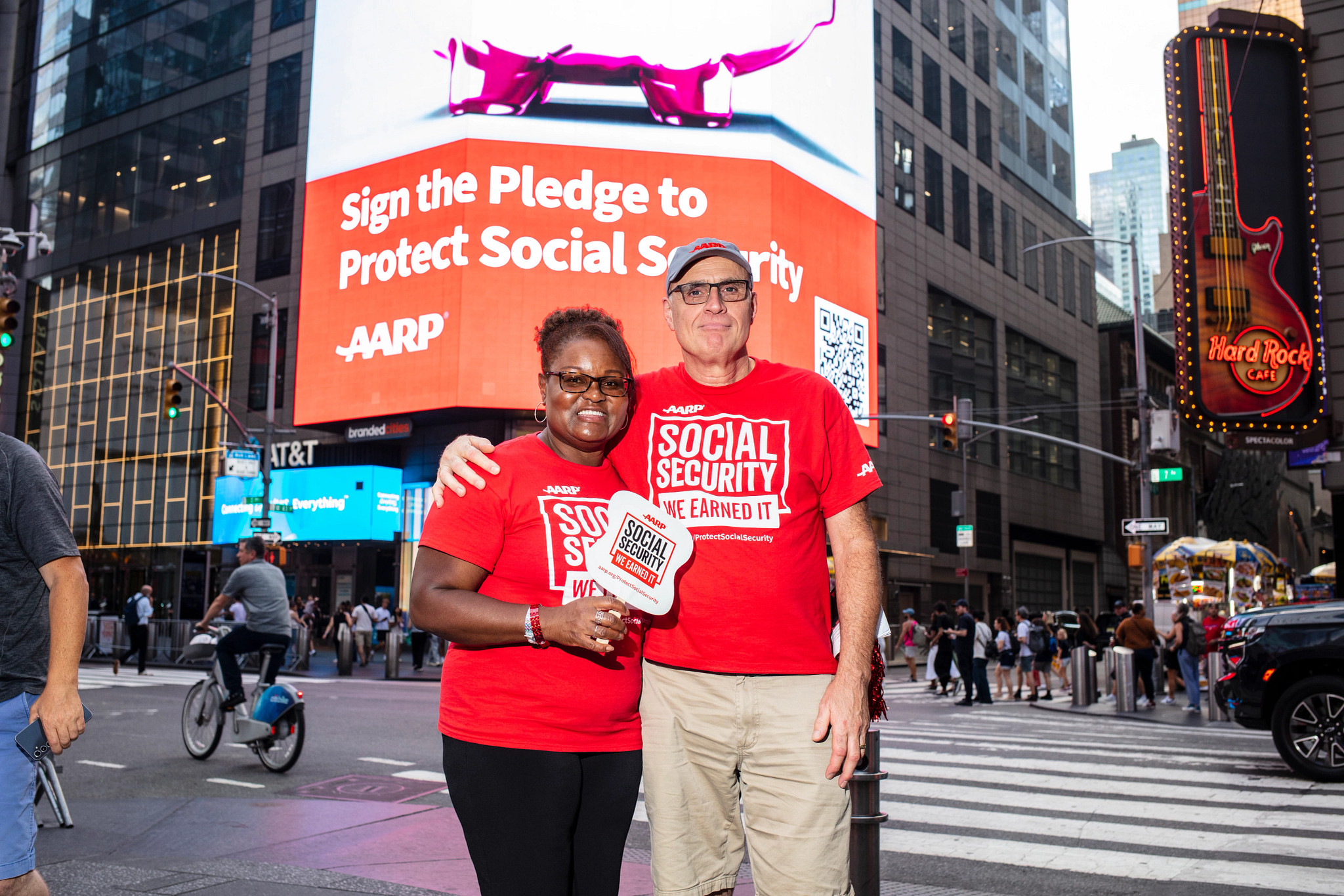 a man and woman in red shirts stand in times square