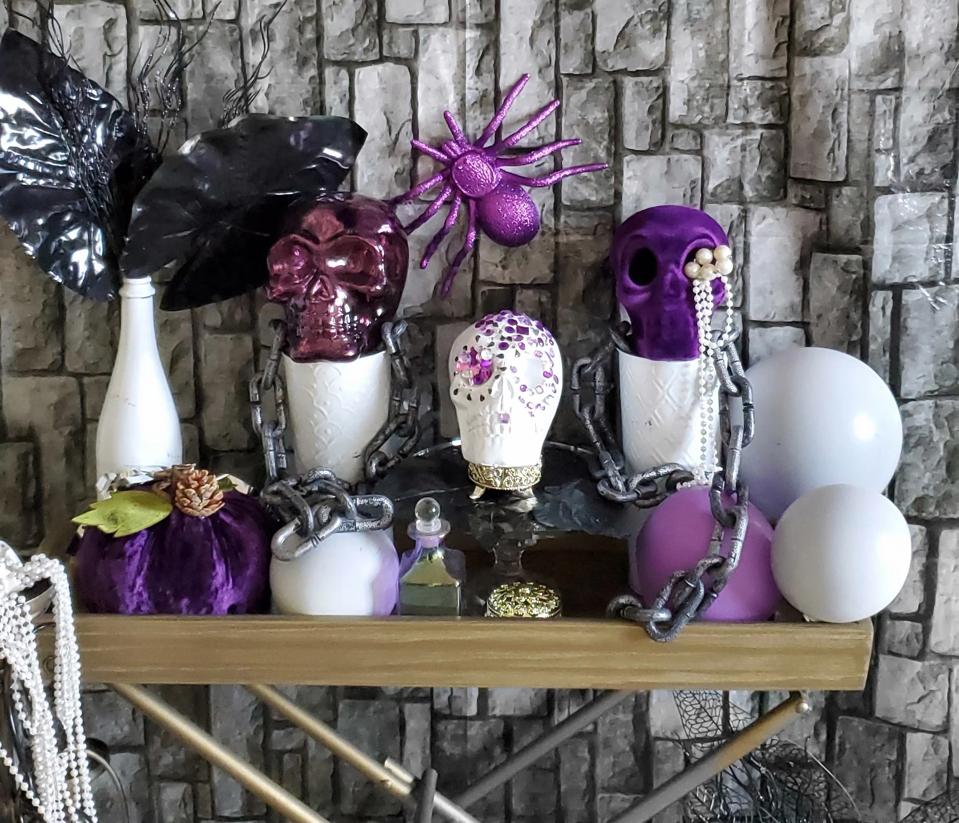 Esqueletos morados, una araña morada y otras decoraciones de Halloween sobre una mesa