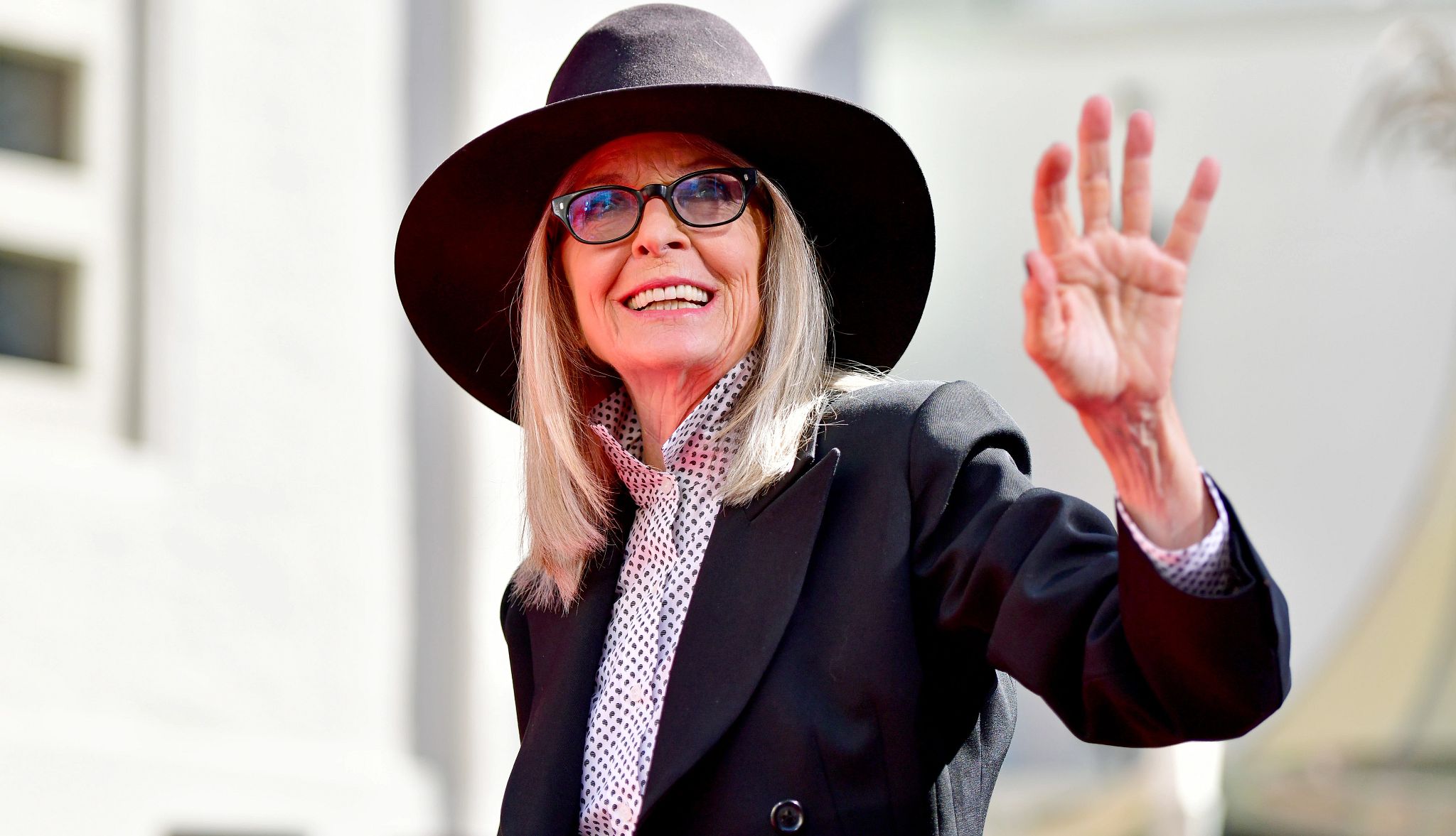 Diane Keaton Obit diane keaton in black hat and glasses waving