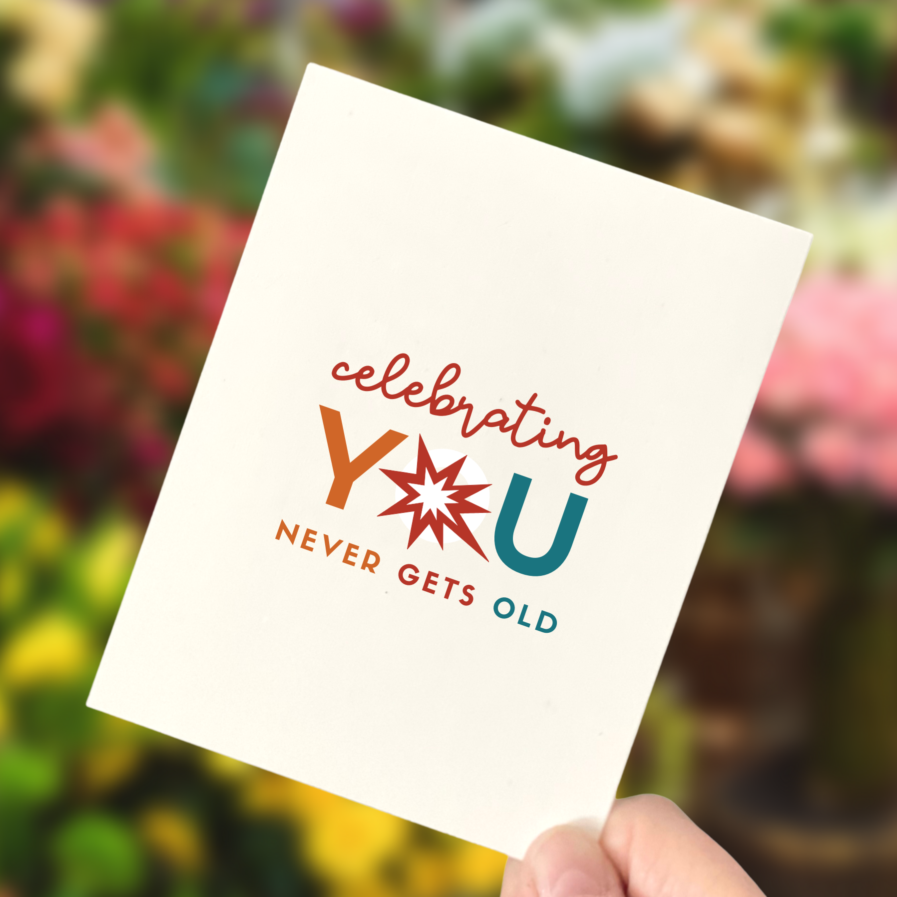an example of an age-friendly birthday card person holding a birthday card that says Celebrating you never gets old