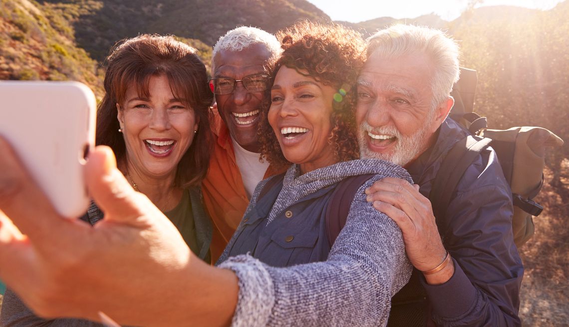 group of senior friends posing for a selfie as they hike in the countryside
