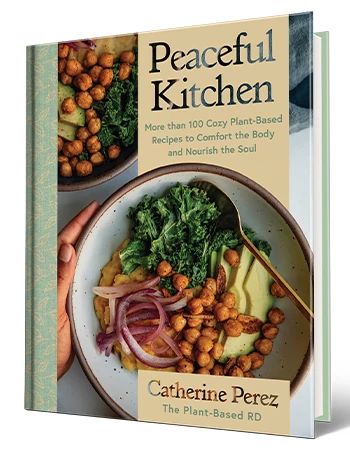 Cookbook ‘Peaceful Kitchen’ by Catherine Perez Cookbook that says Peaceful Kitchen, Catherine Perez, The Plant-Based RD; bowl of greens, chickpeas, avocado and onion on cover