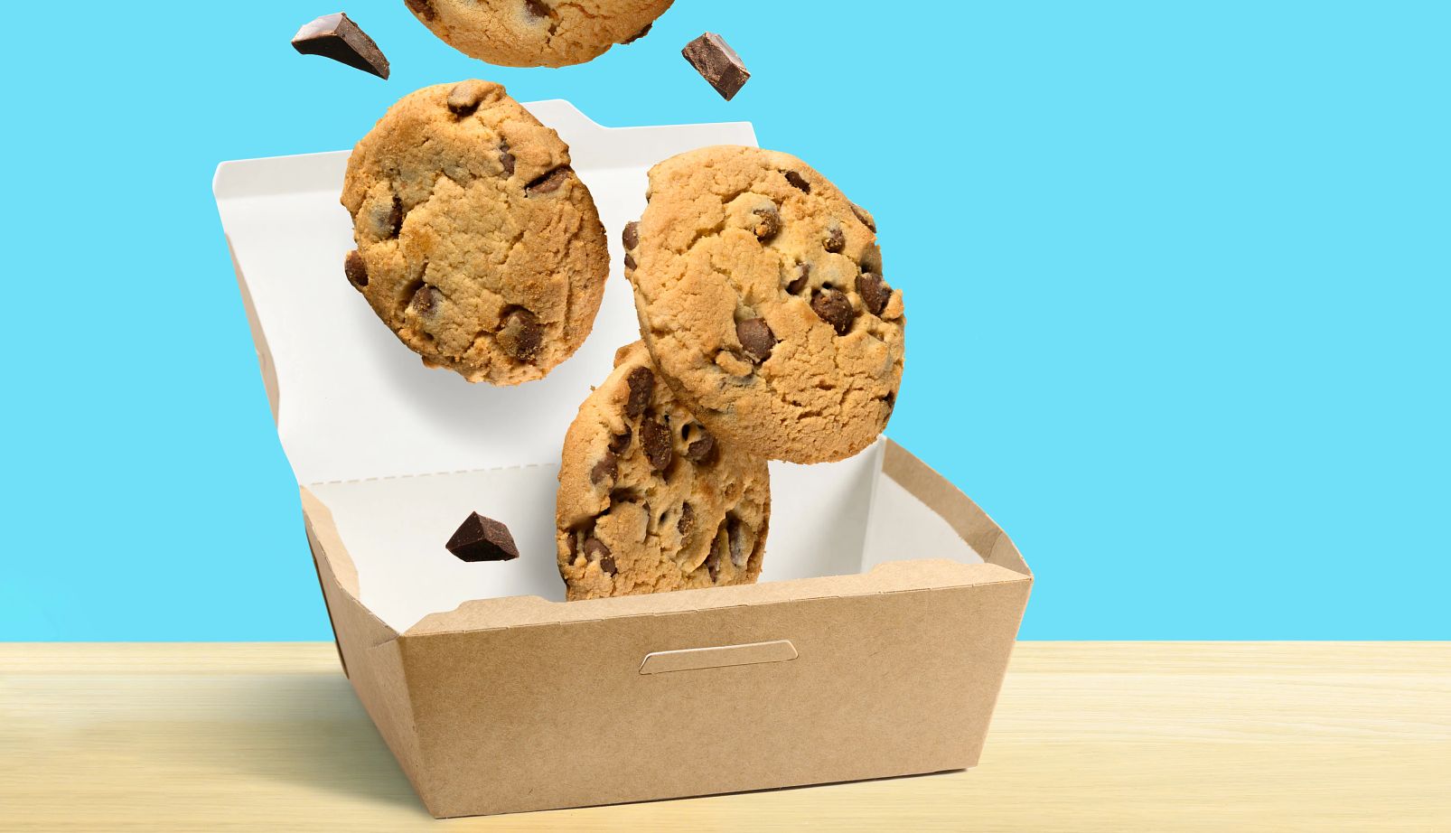 Cookie day deals Chocolate chip cookies falling in paper box over turquoise blue background