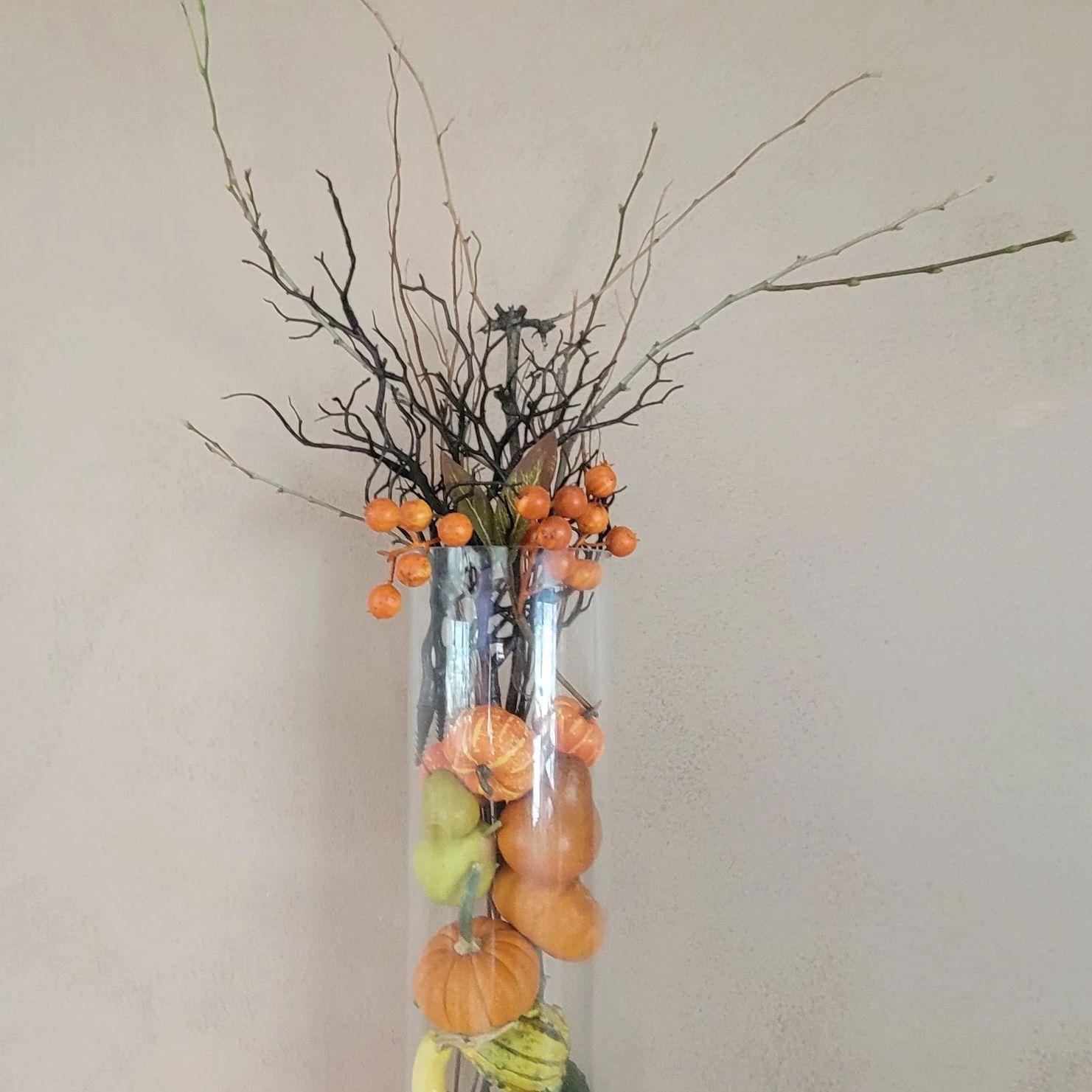 Dollar Tree has various Halloween ornaments fake pumpkins, ghords and twigs inside a vase