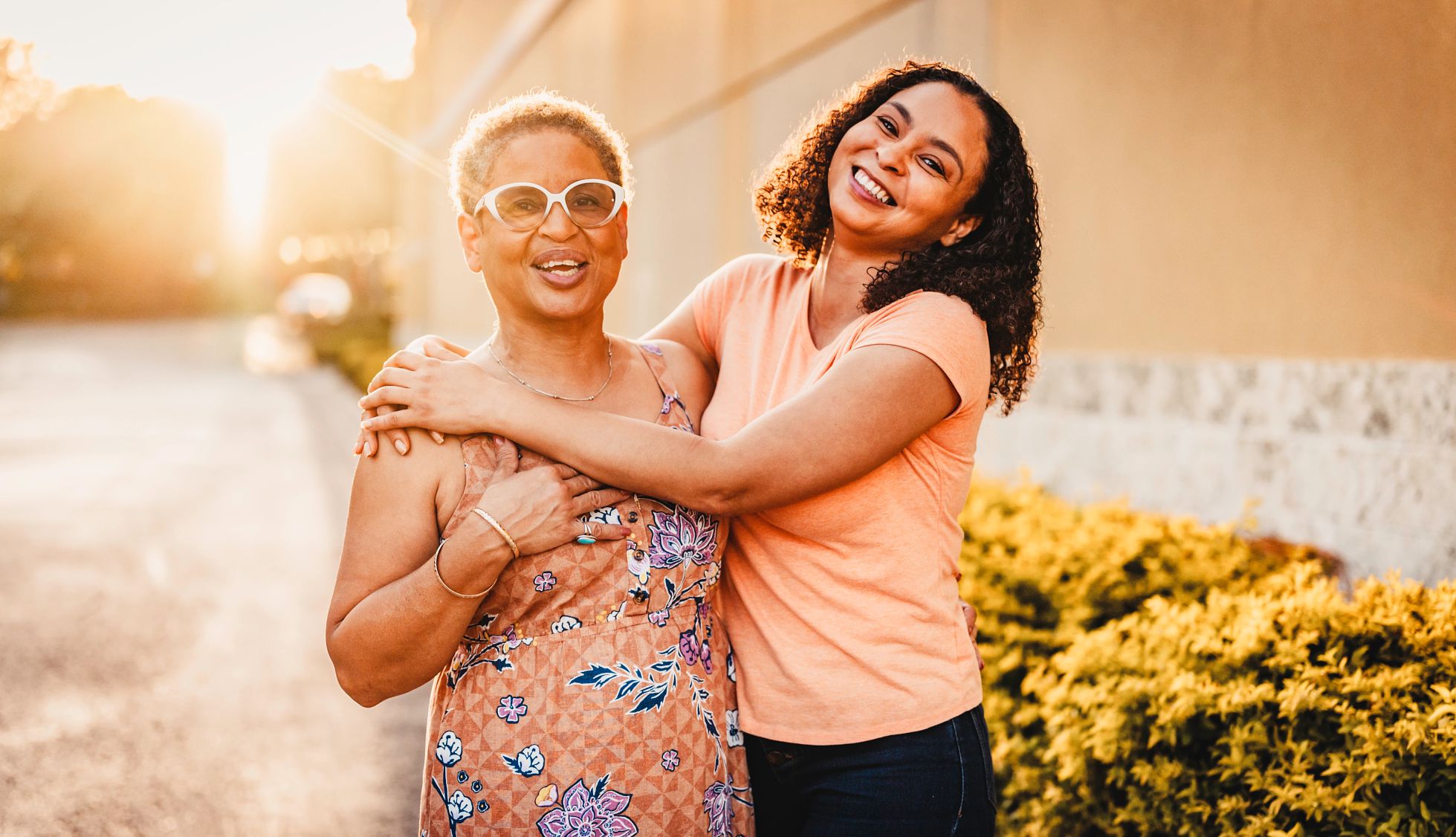 AARP Vision for Aging two women hug and smile in the sunlight