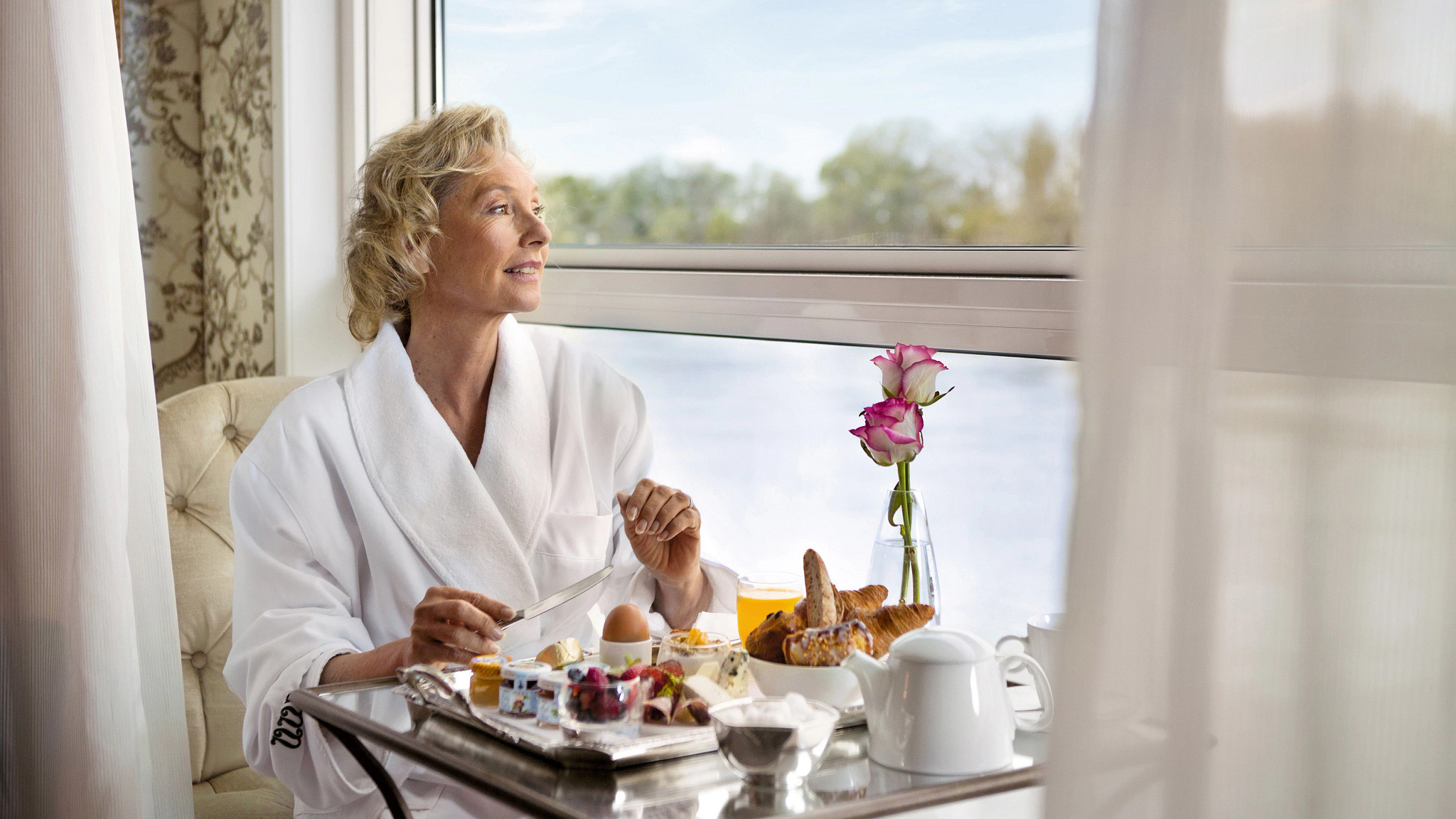 Woman in a hotel robe eating breakfast