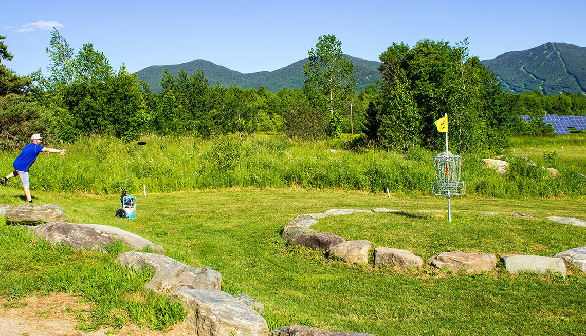 a man throwing a disc at a disc golf course
