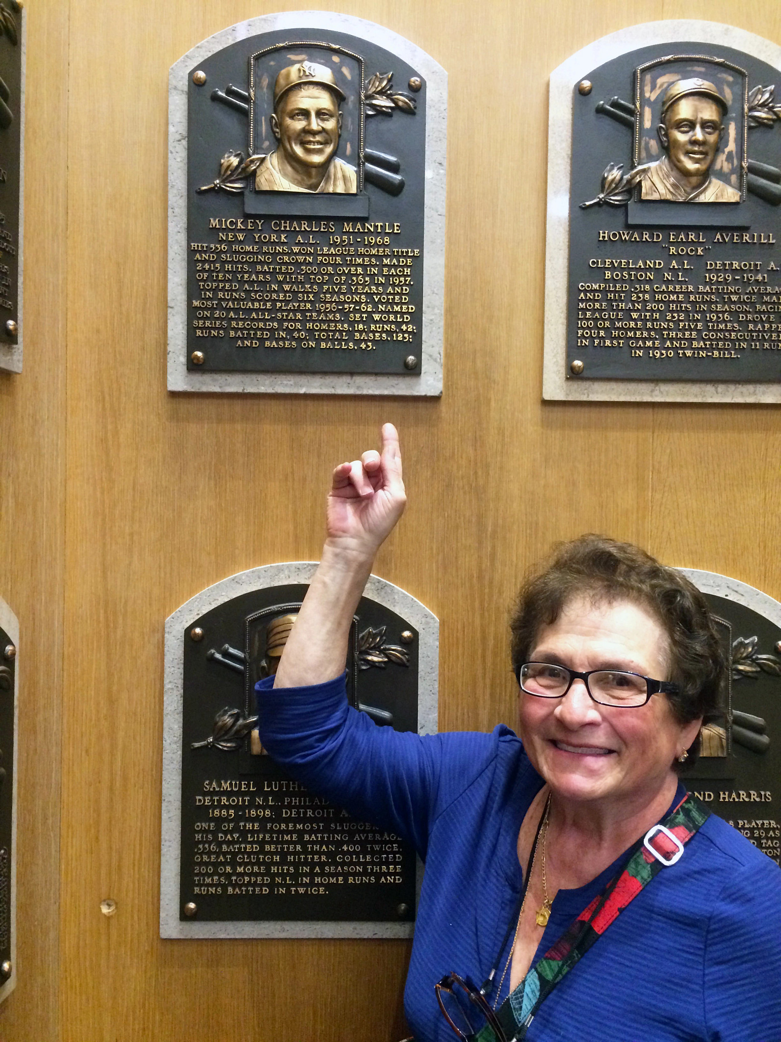 a photo shows the author's mother, Annamaria, pointing at Mickey Mantle’s tribute plaque to at the National Baseball Hall of Fame