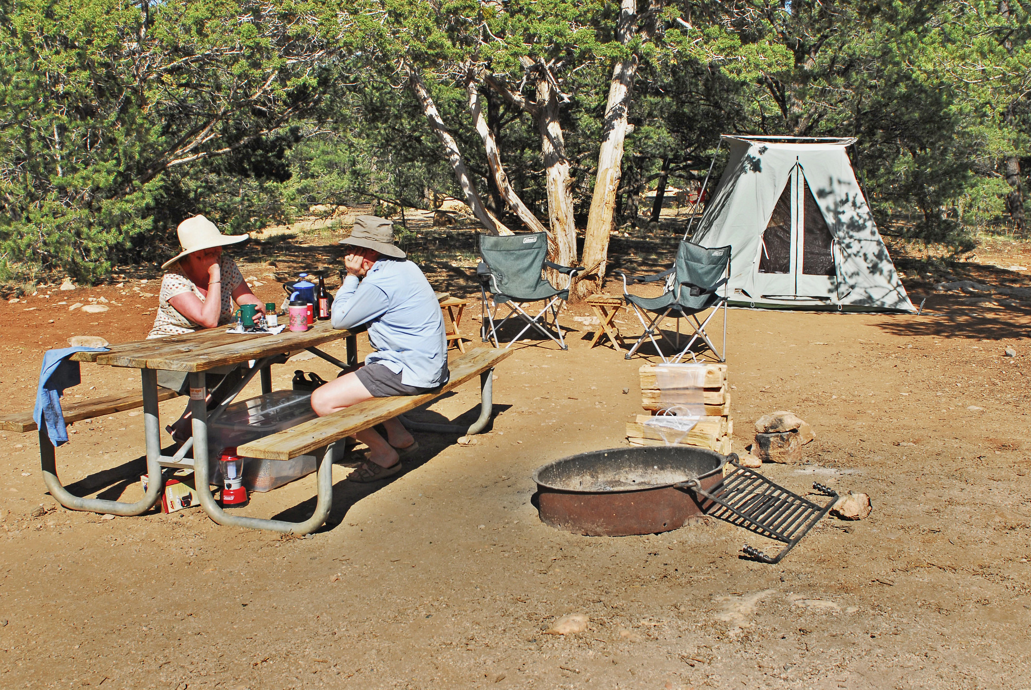 two people sit at a campsite