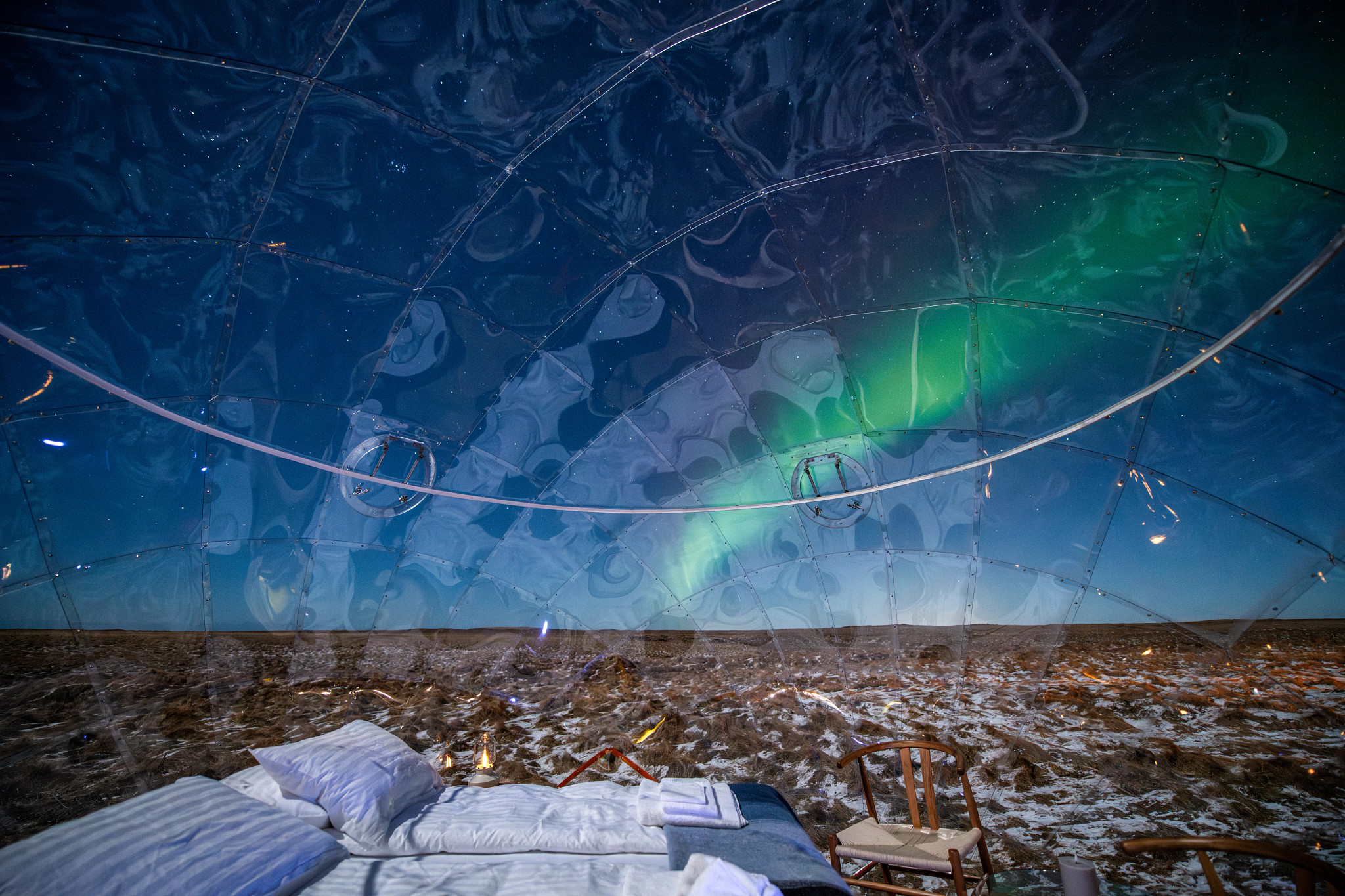 the northern lights shown through a clear igloo