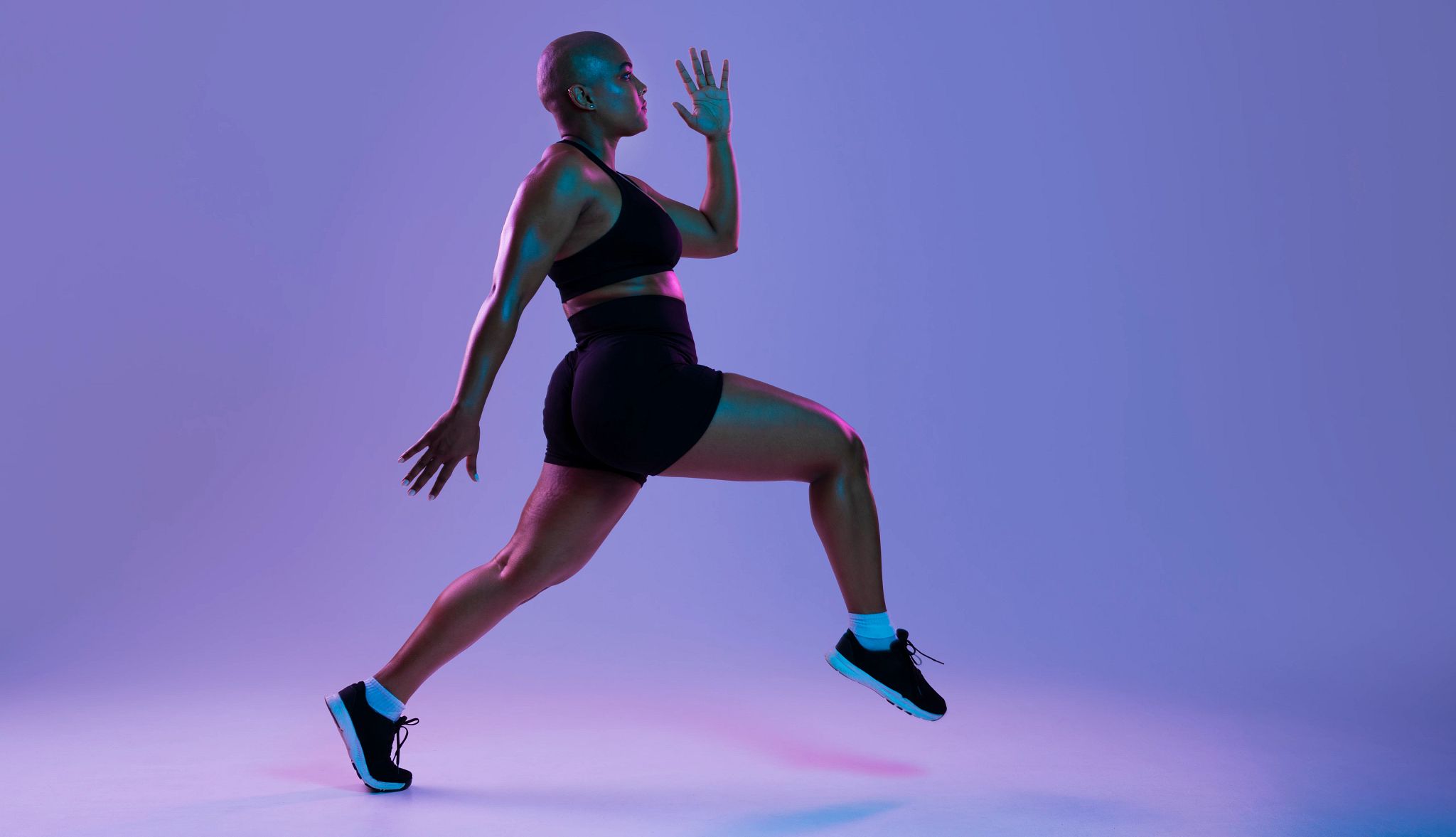 Exercise and Cancer A photo shows a woman exercising in front of a purple backdrop.