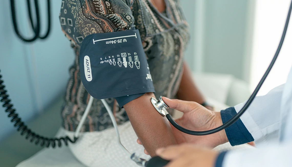 A woman getting her blood pressure checked at a doctor's office