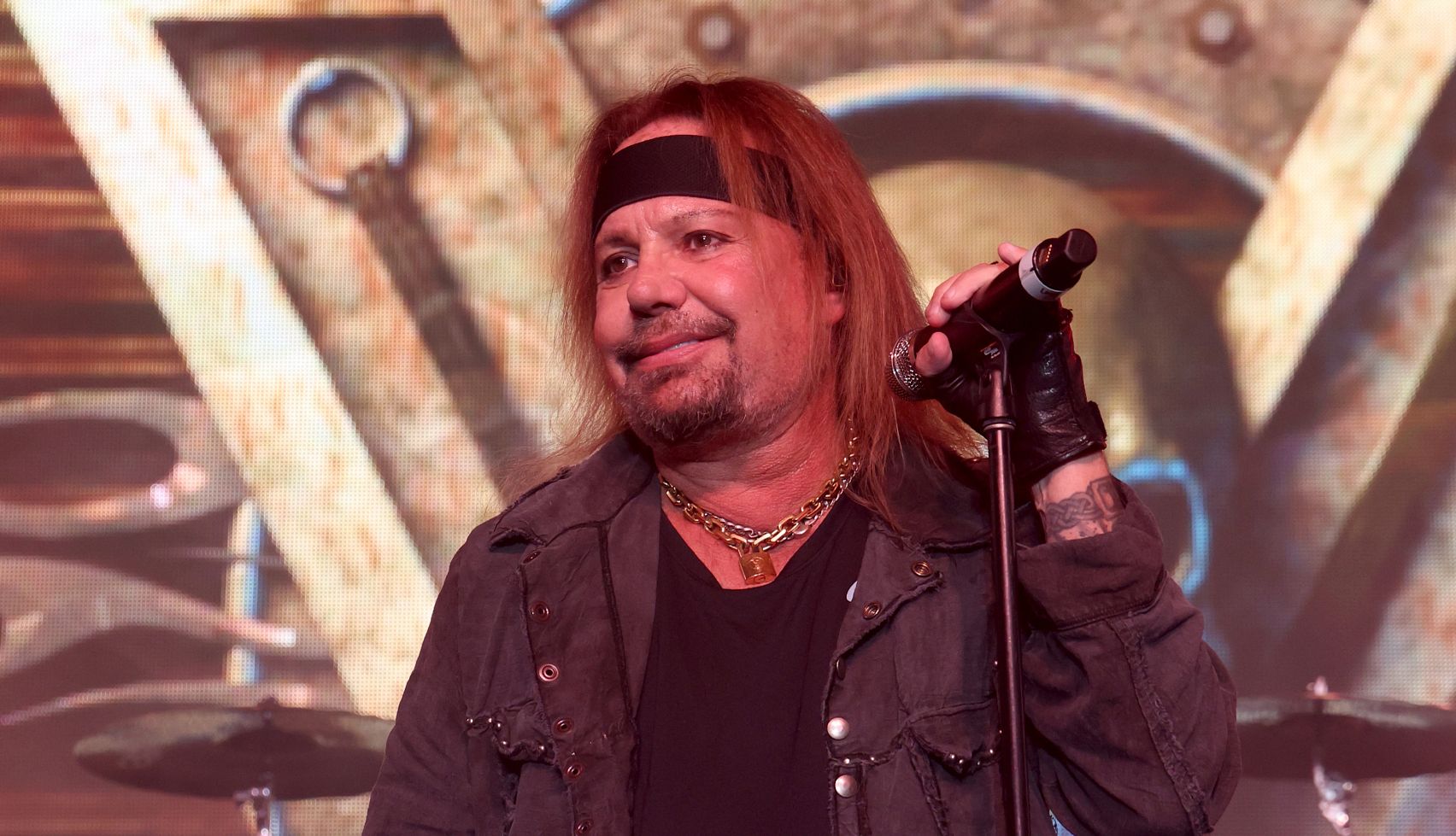 Mötley Crüe’s Vince Neil Has Had Four Strokes vince neil standing behind a microphone