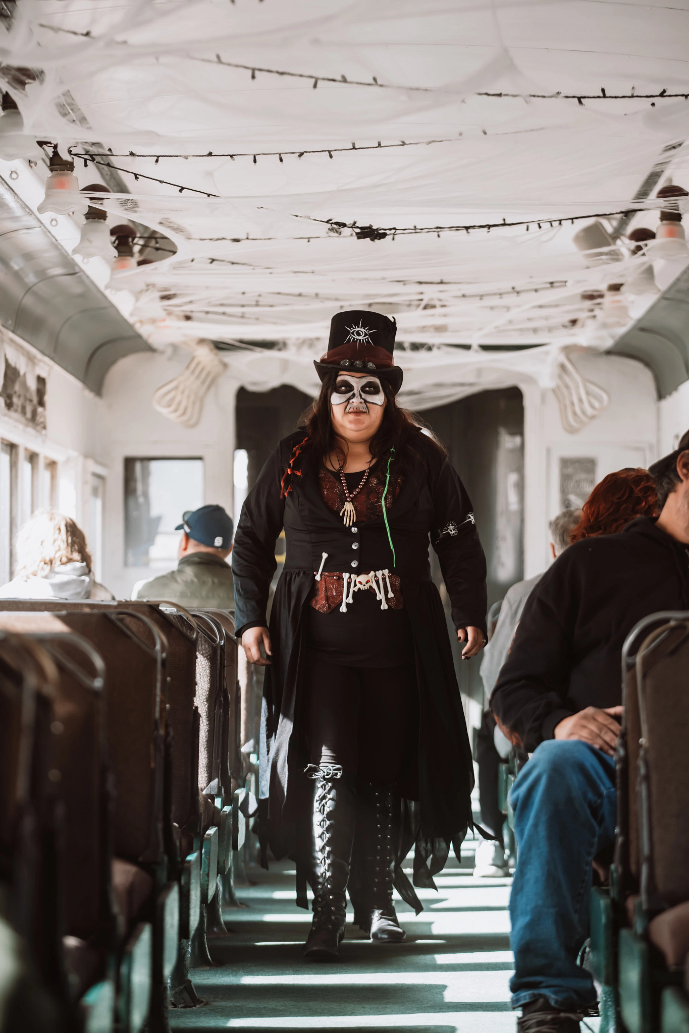 a person in a halloween costume walking down the aisle of a train car