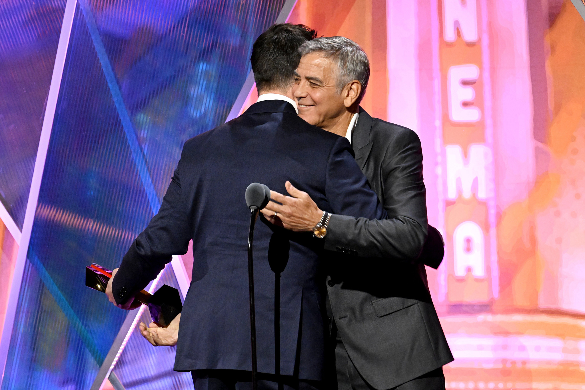 noah wyle accepting an award from george clooney