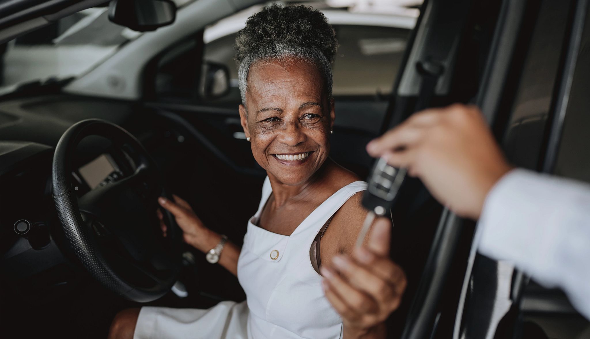 Smart Guide to Car Rentals a woman sitting in a car and being handed keys