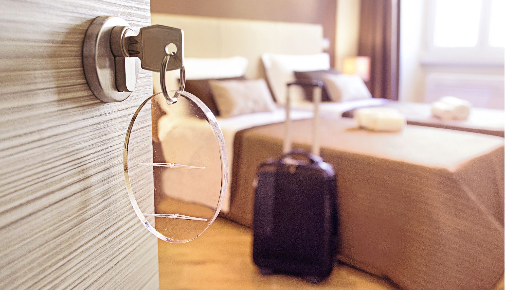 Upgrading a hotel room may not be worth the extra cost an open hotel room door showing bed and luggage in the background