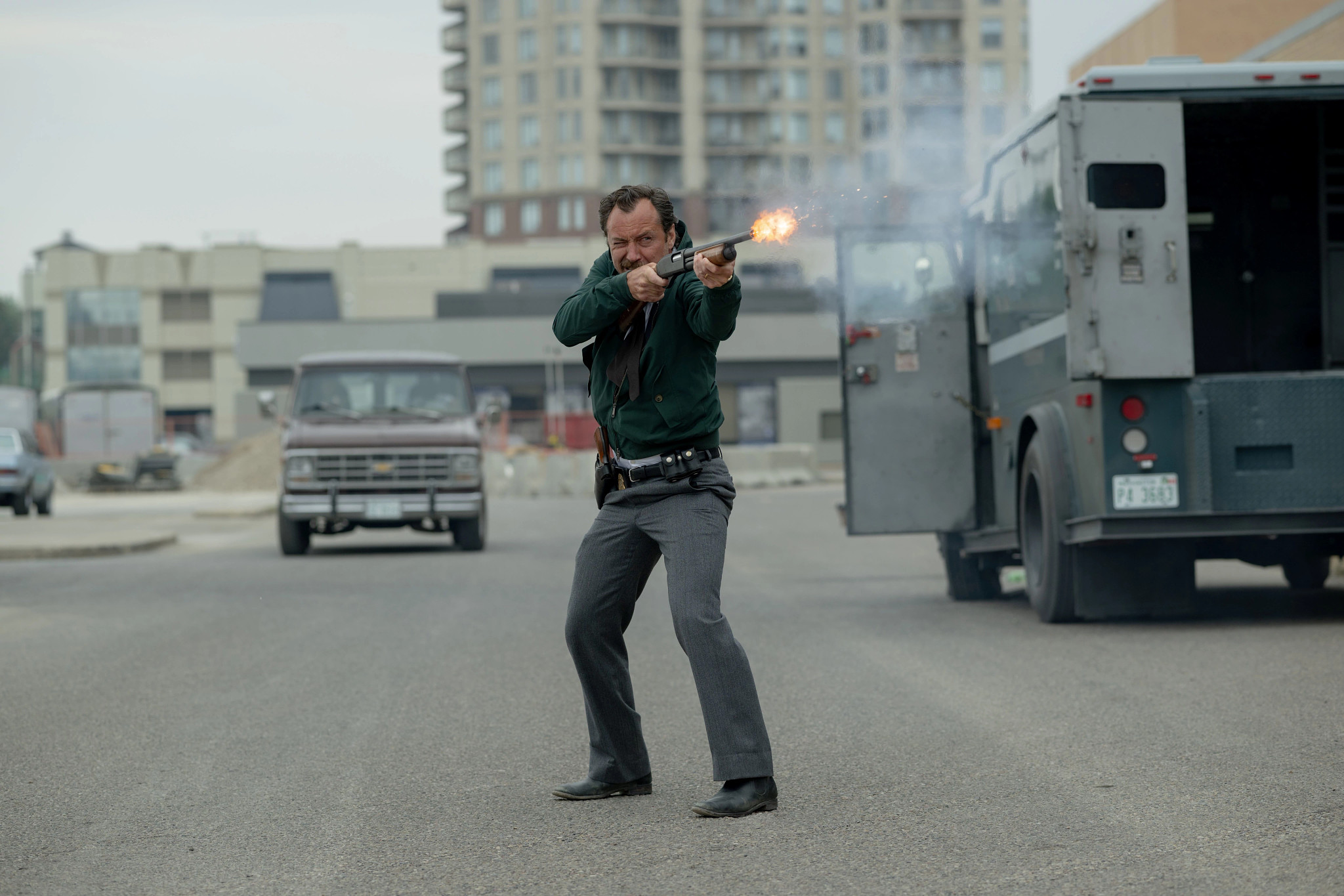 Jude Law in The Order Jude Law firing a shotgun on the street in the movie The Order