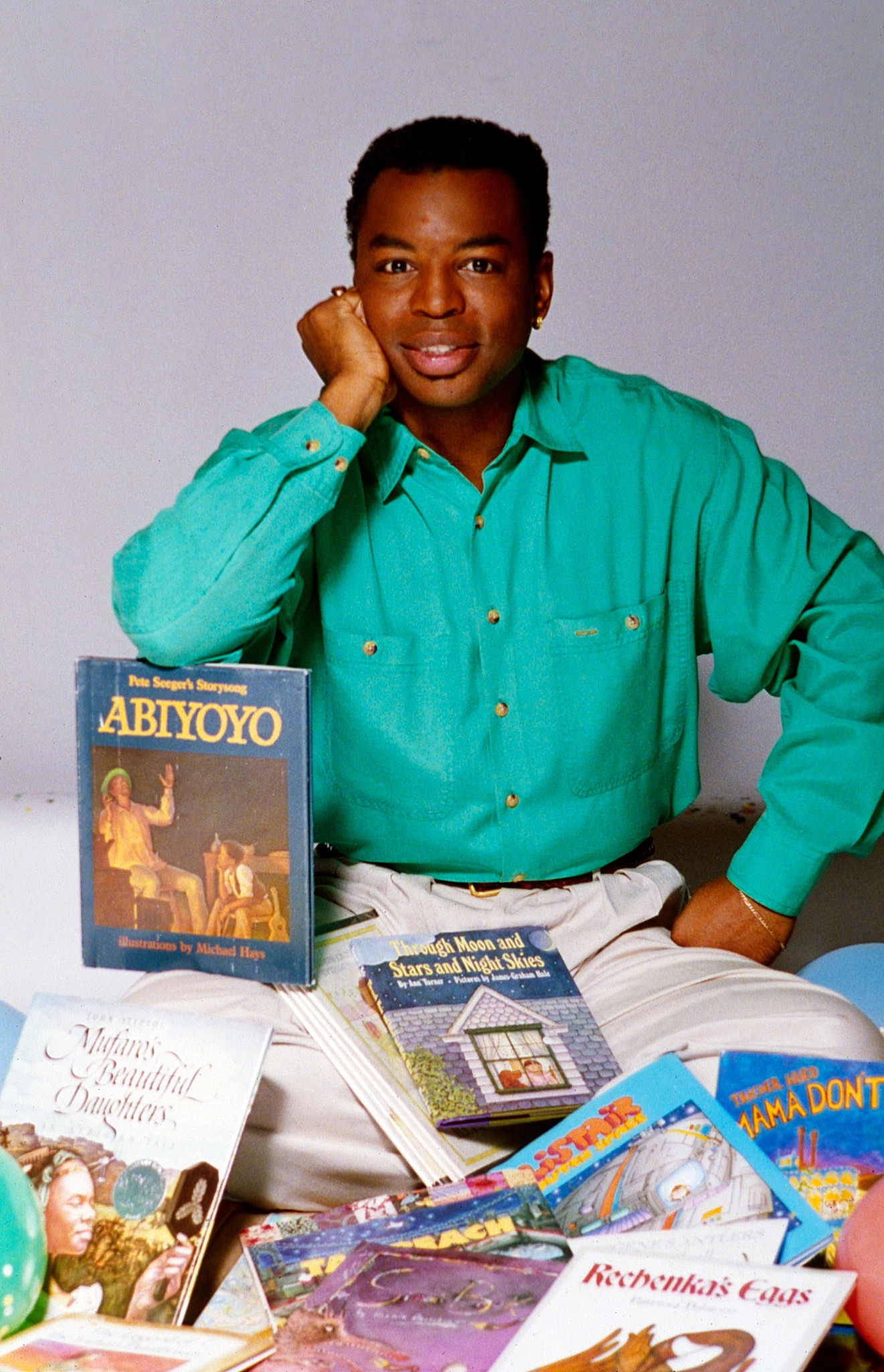 levar burton posing with books as the host of reading rainbow