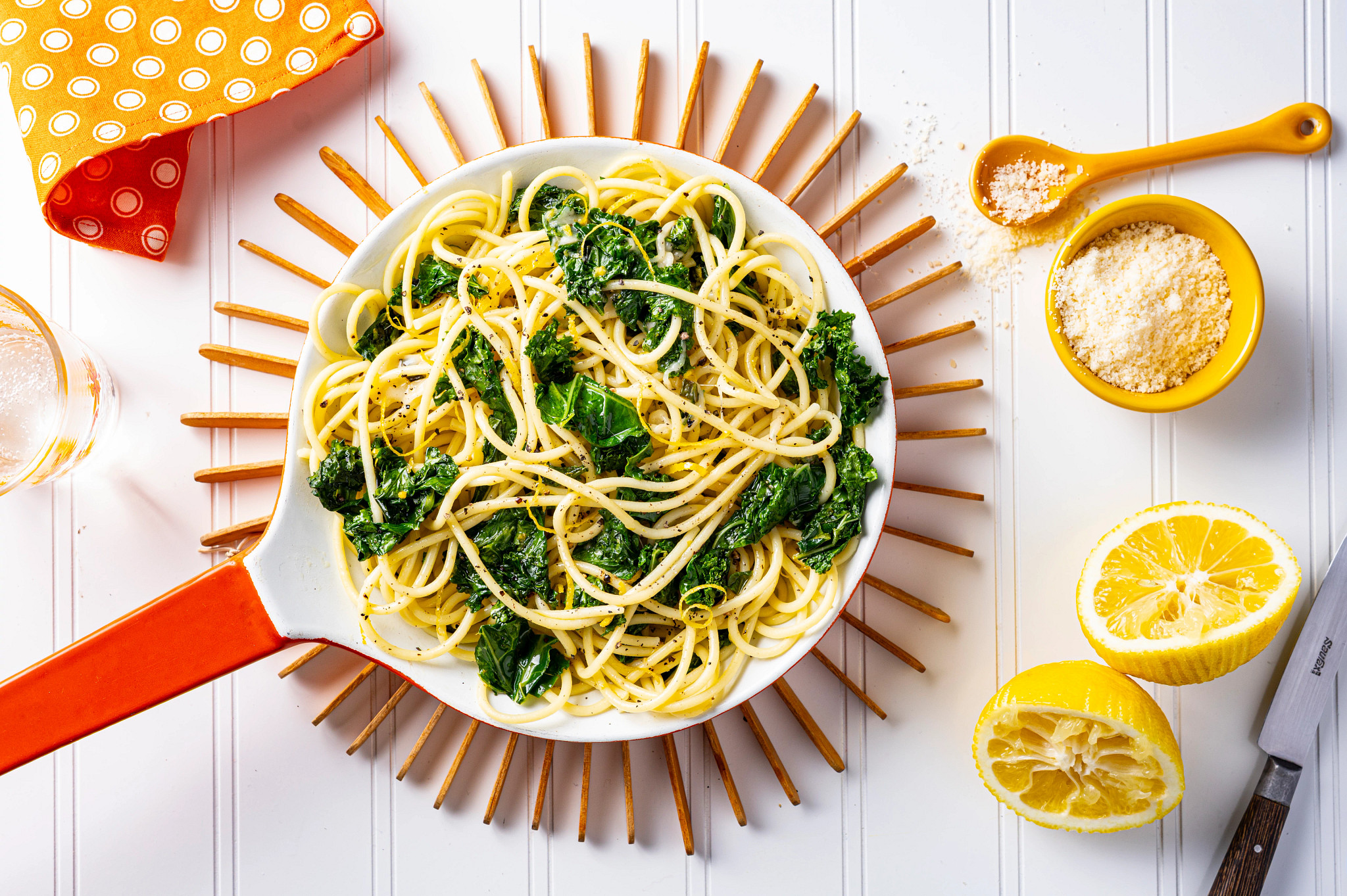 Overhead view of Lemon Scallion Pasta in a pan with lemons and a polka dot napkin