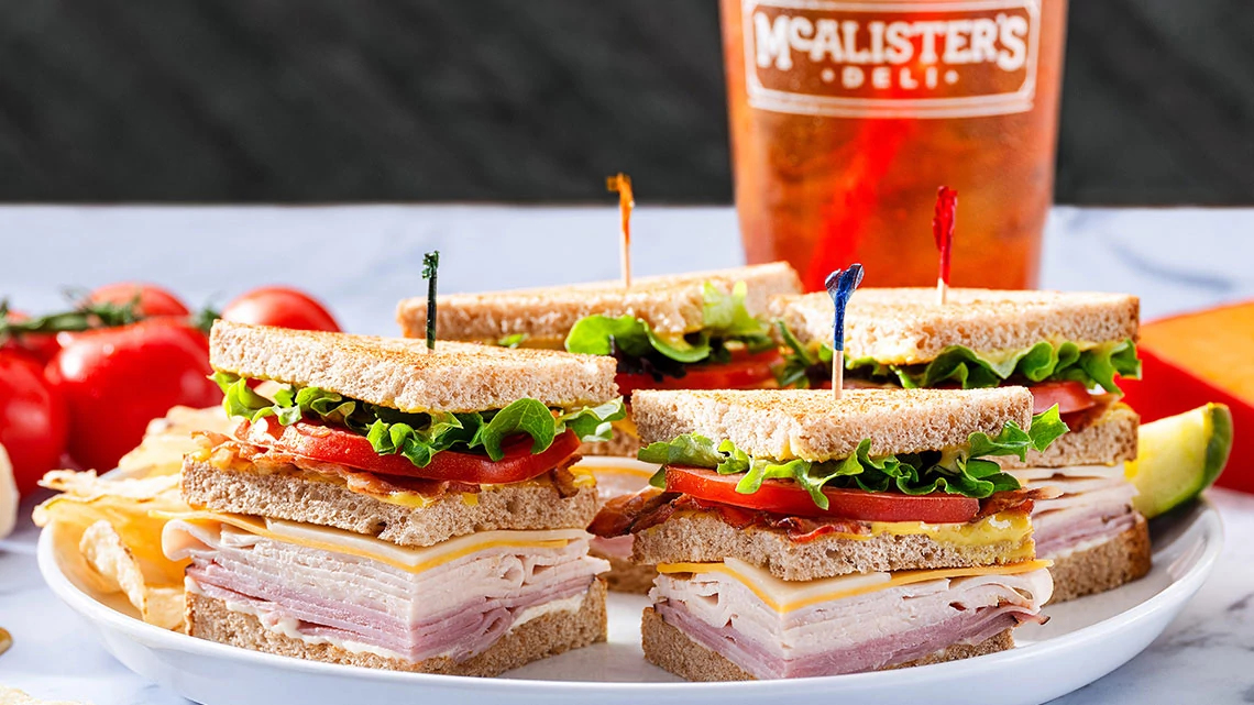McAlister's Deli classic club sandwich on a plate with ice tea drink