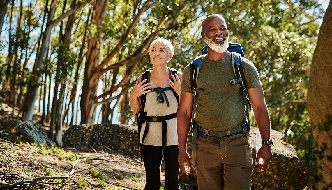 Your gut microbiome and your brain can both benefit from regular outdoor exercise A man and woman hiking together in a wooded area