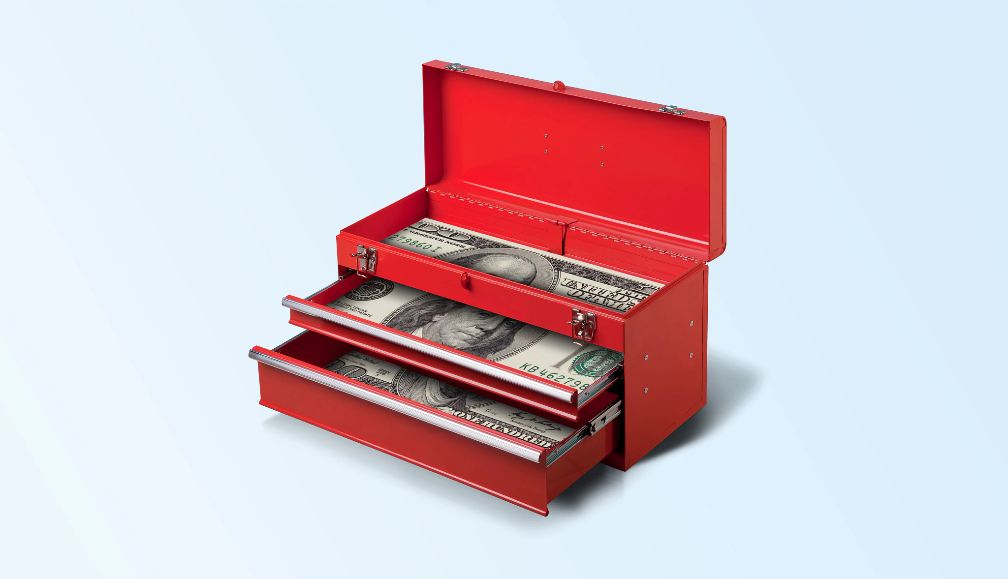 a red tool box with drawers pulled out. the drawers are lined with large one hundred dollar bills