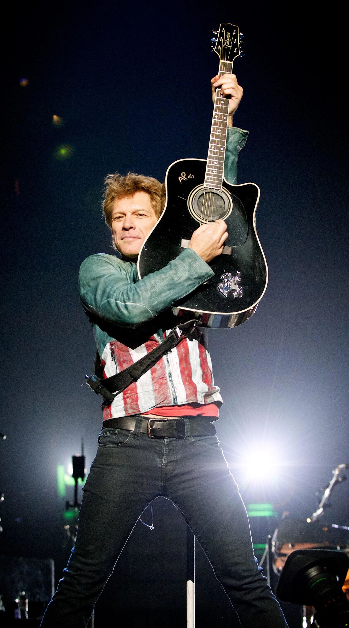 Jon Bon Jovi raises his guitar in the air during his performance at American Airlines Center in Dallas