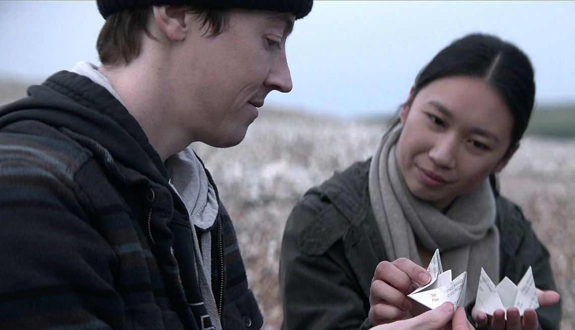 Alex Sharp and Jess Hong in 3 Body Problem Alex Sharp and Jess Hong holding paper folded up into origami in the Netflix series 3 Body Problem