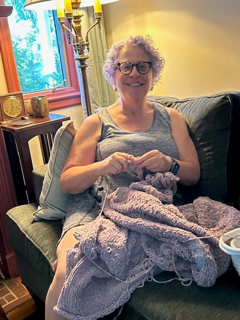 a photo shows Tina B. Kane knitting