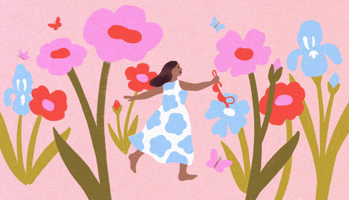 An older woman walking through a garden of oversized pink, blue and red flowers while holding a bra.