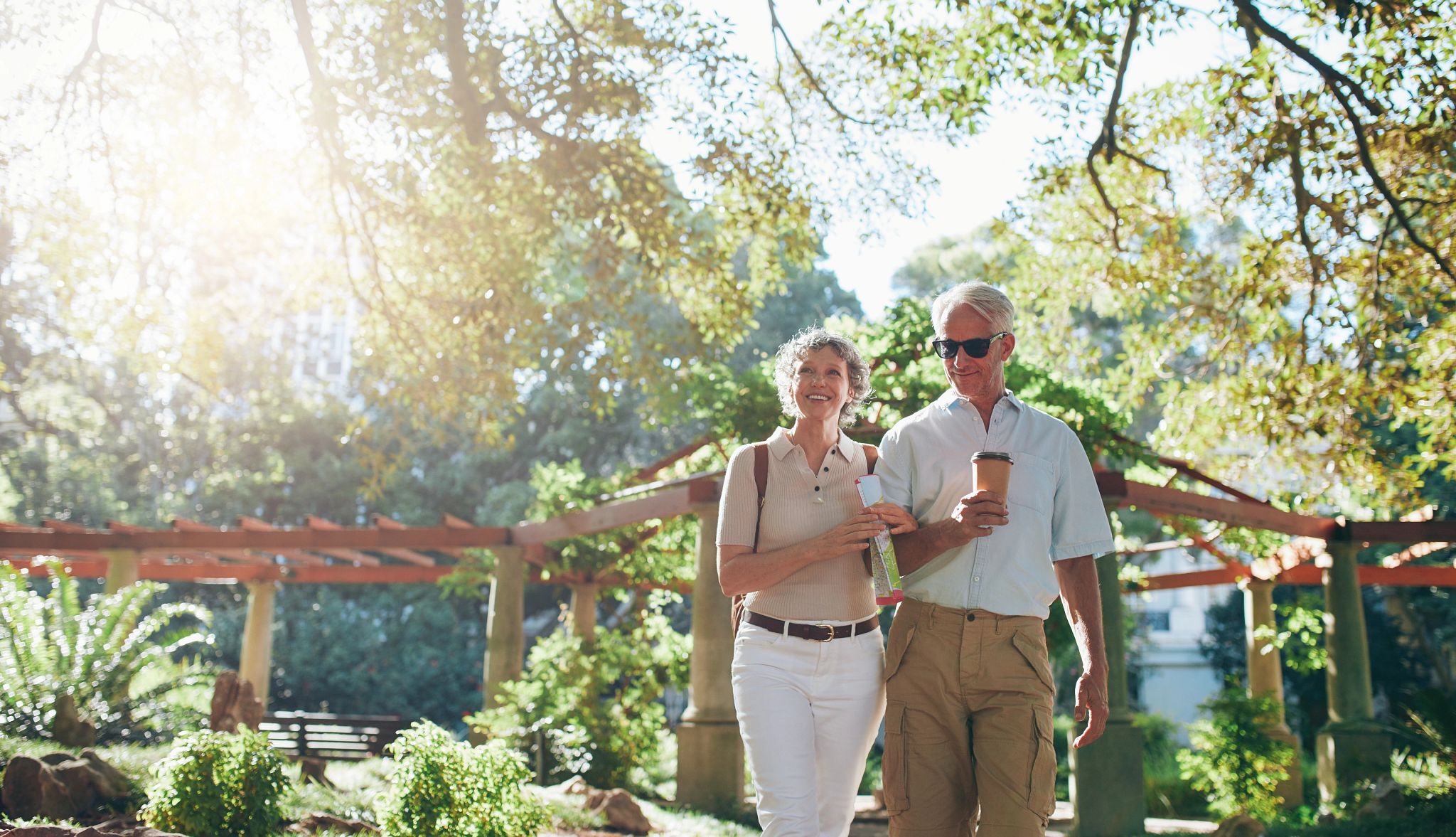 Portrait of couple of senior tourist walking through a park on a summer day. mature couple on a vacation. Portrait of couple of senior tourist walking through a park on a summer day. mature couple on a vacation.