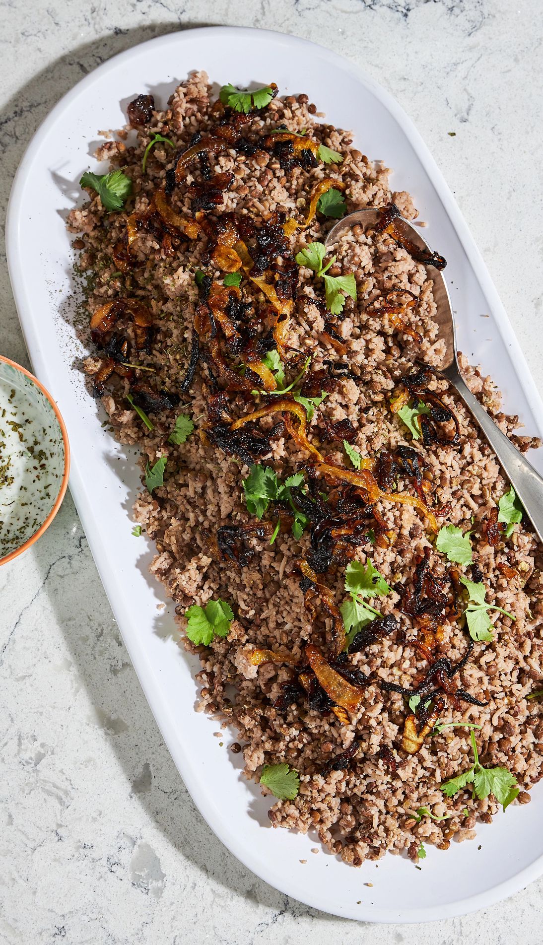 M'jedrah, Syrian-Jewish Rice and Lentils M'jedrah, Syrian-Jewish rice and lentils, on a dish with spoon in it