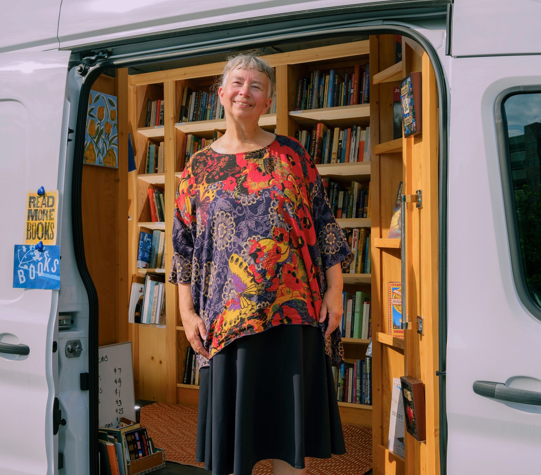 The Bookstore That Comes to You A photo shows Rita Collins standing inside the van that houses her traveling bookstore