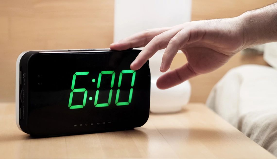 Mano que apaga un reloj despertador
