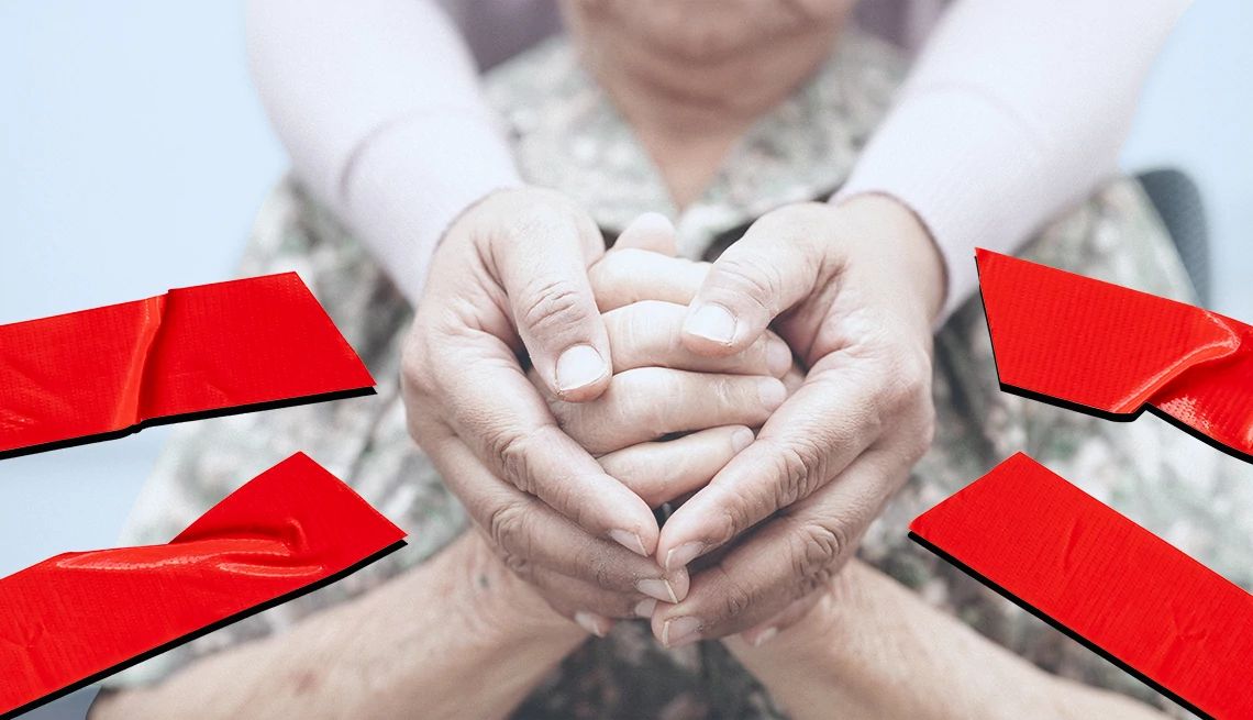 Las manos del cuidador y del receptor de cuidados en el medio de una cinta roja rota
