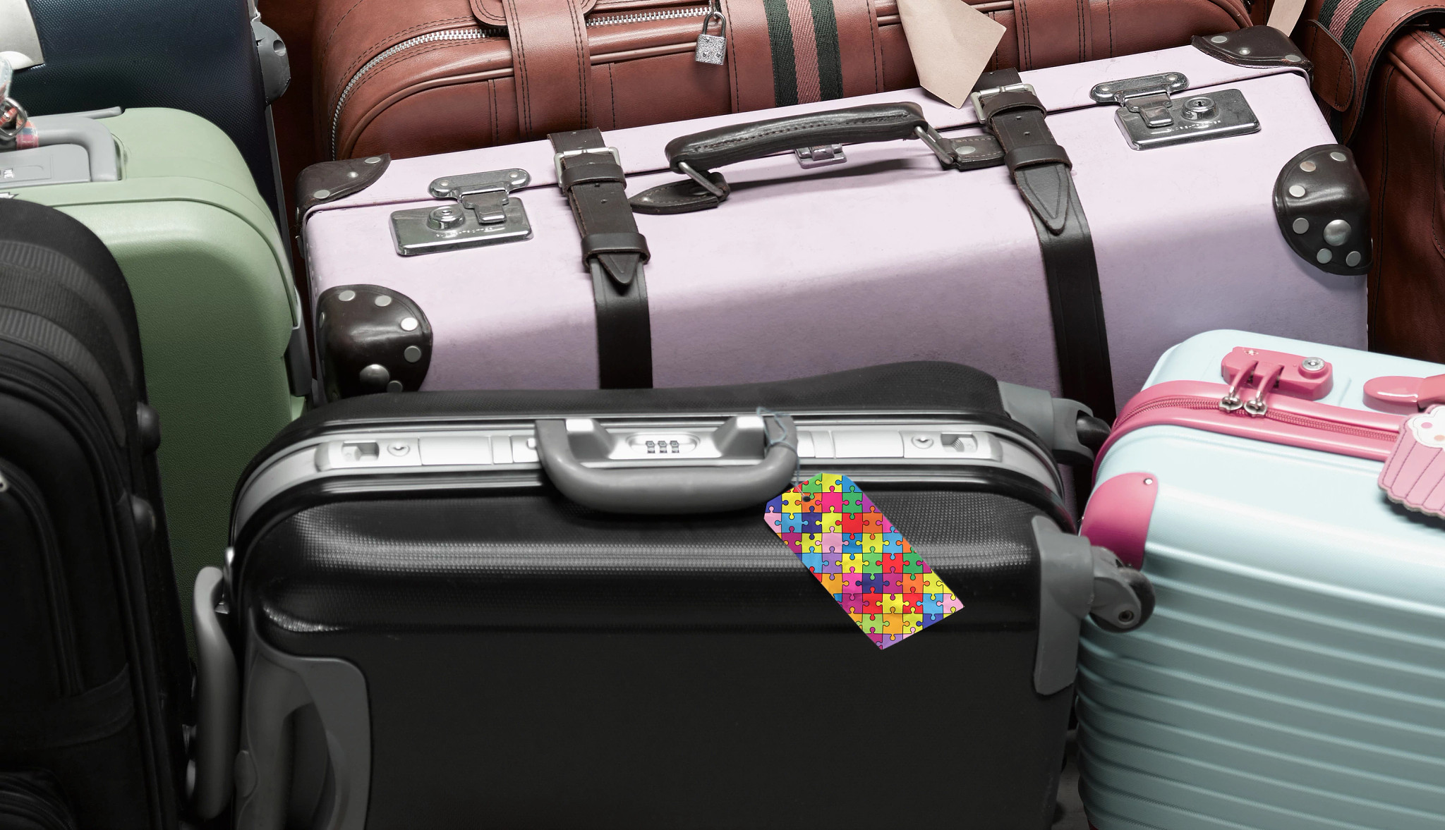 an assortment of luggage with an autism awareness luggage tag