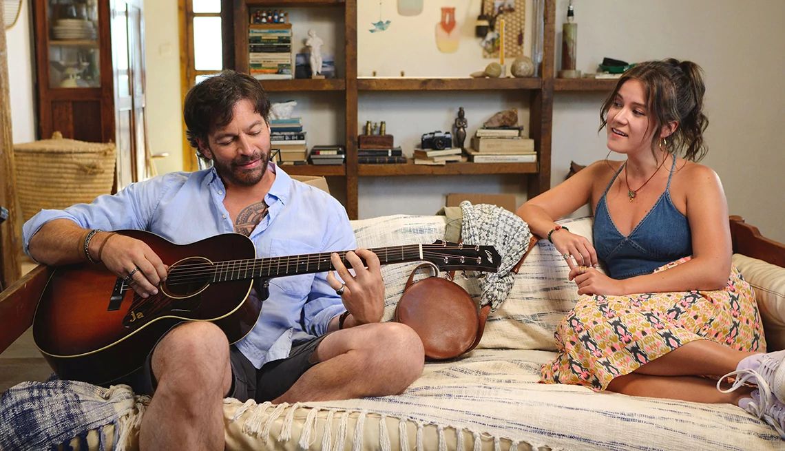 Harry Connick Jr. playing a guitar with Ali Fumiko Whitney sitting next to hin in the film Find Me Falling