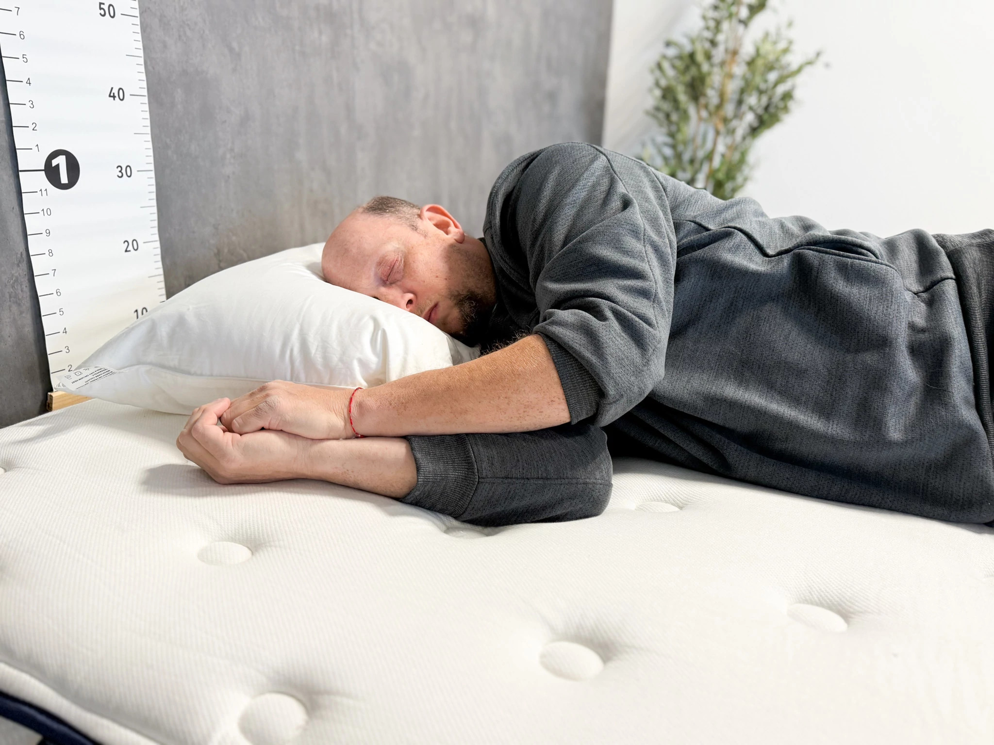 An older adult man testing the Peacock Alley Down Alternative Pillow on his side.