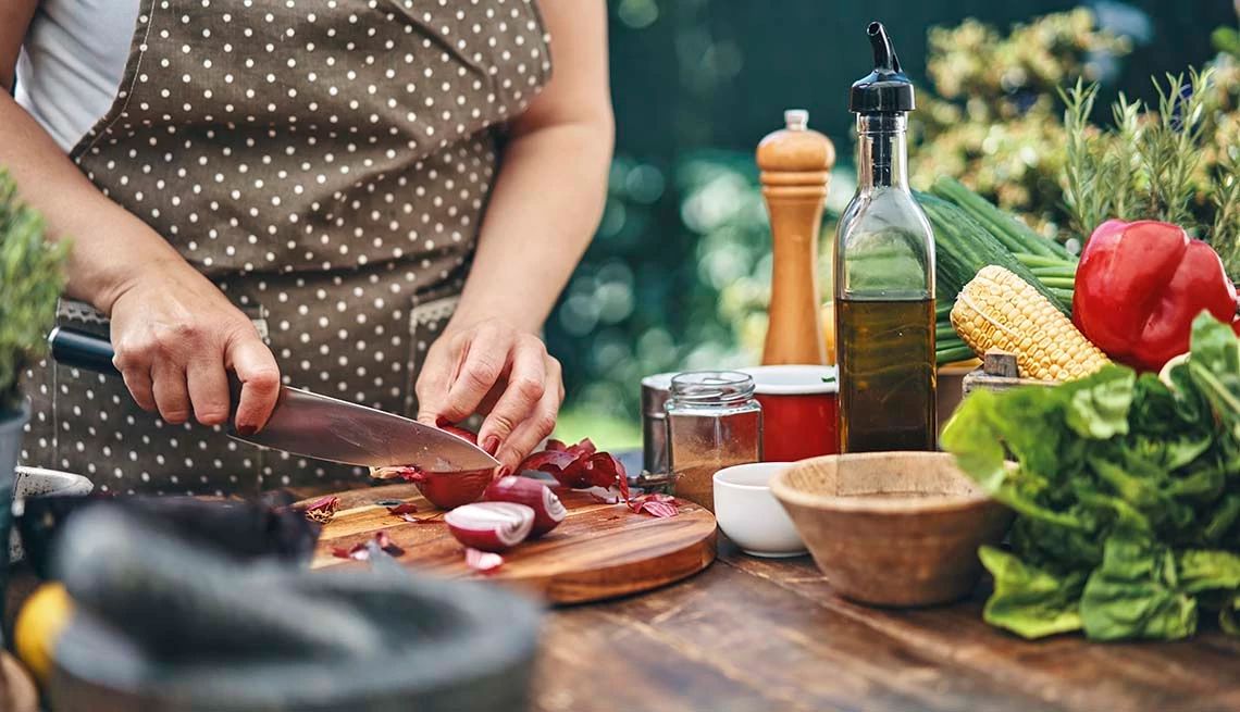 Nutrition has an effect on your cognitive wellness A person cutting onions on a wooden cutting board