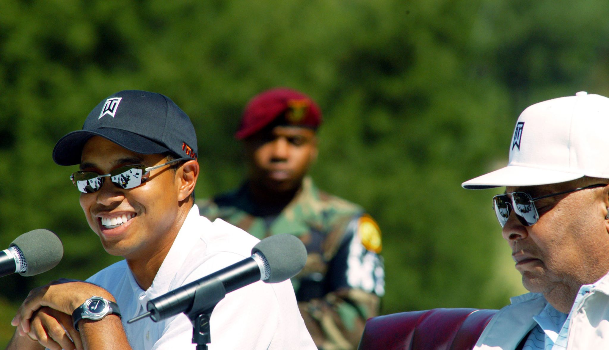 Tiger and Earl Woods at press conference Tiger and Earl Woods sitting next to each other with microphones in front of them