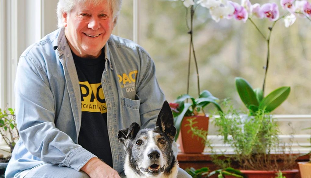 Buzz Miller brings pets and people together A man, Buzz Miller, smiling in a home with a dog