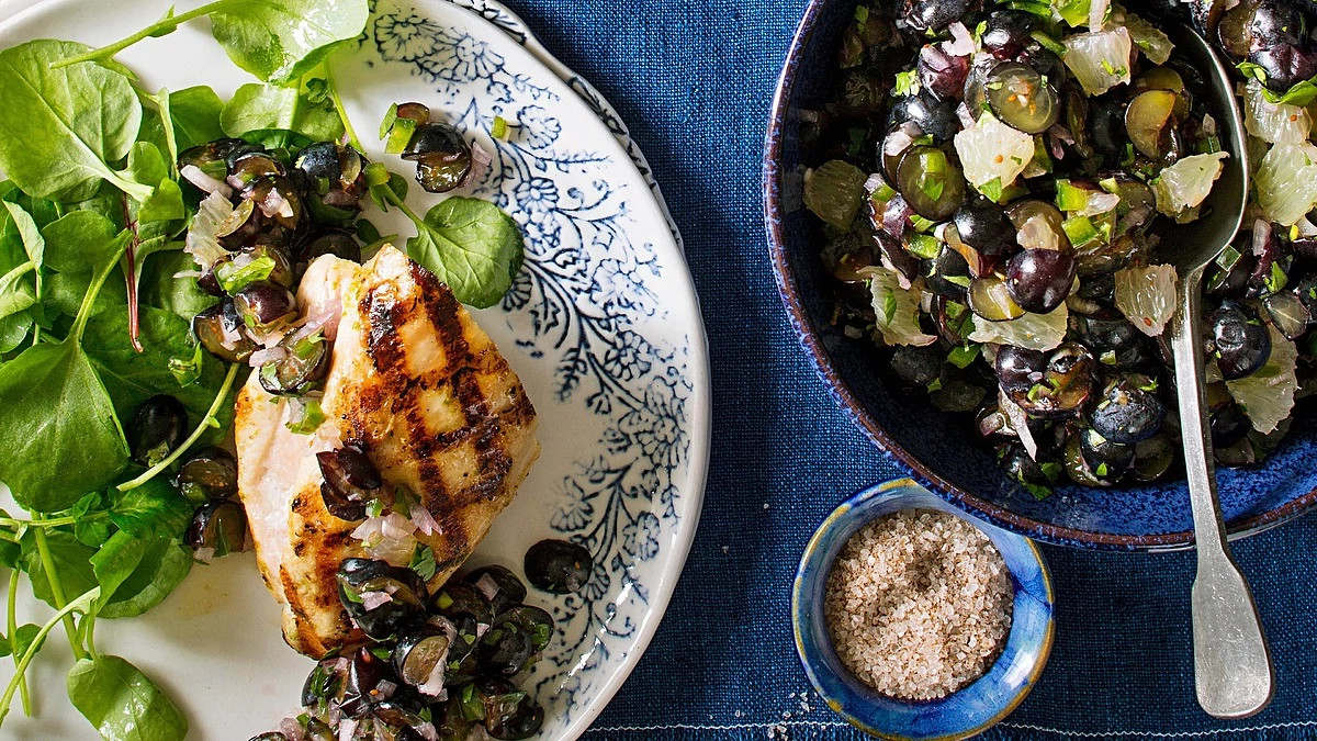 A close-up view of grilled chicken with blueberry-lime salsa
