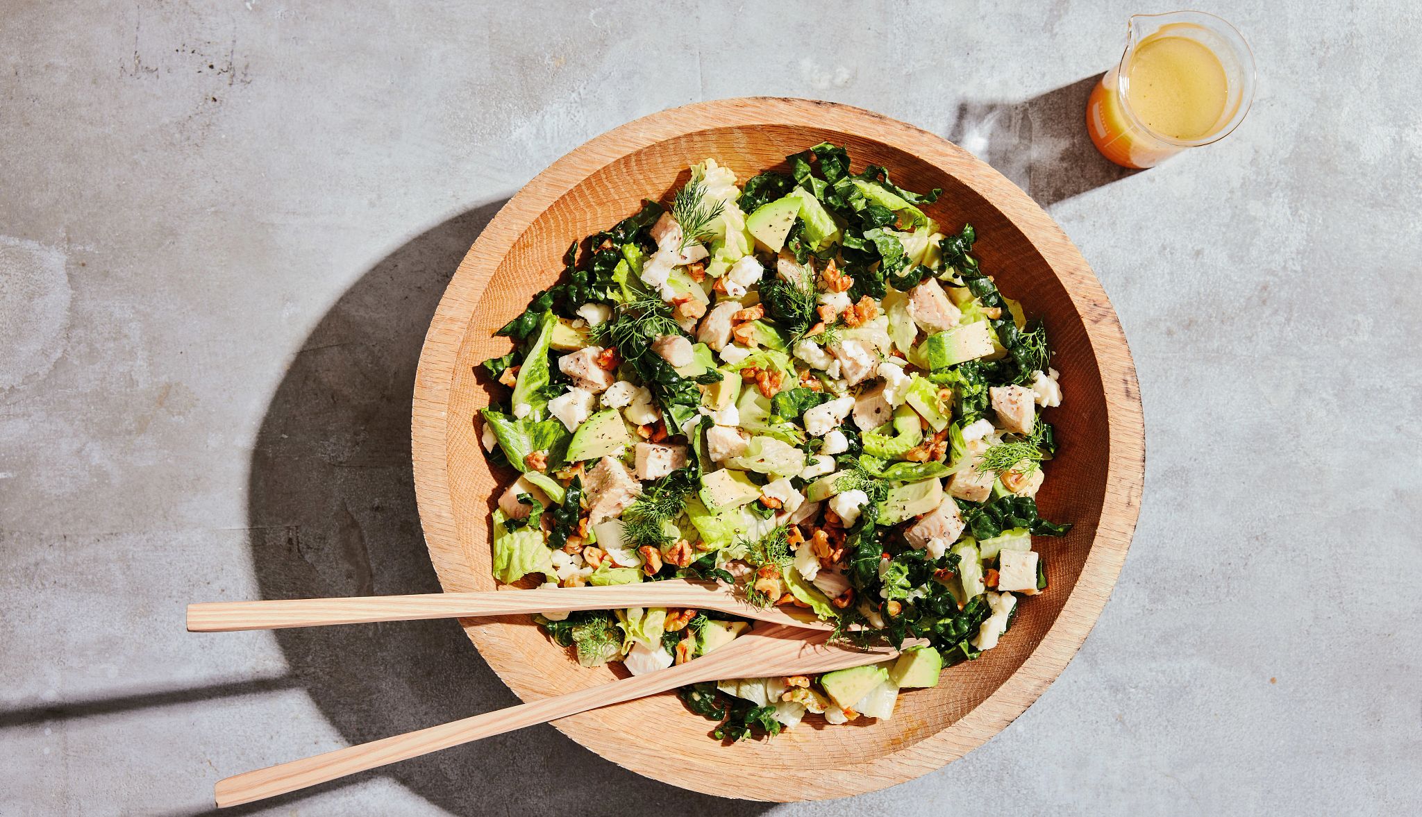 Chicken and Avocado with Hot Honey Sauce Vinaigrette Salad containing lettuce, chicken, avocado and vinaigrette in wooden bowl