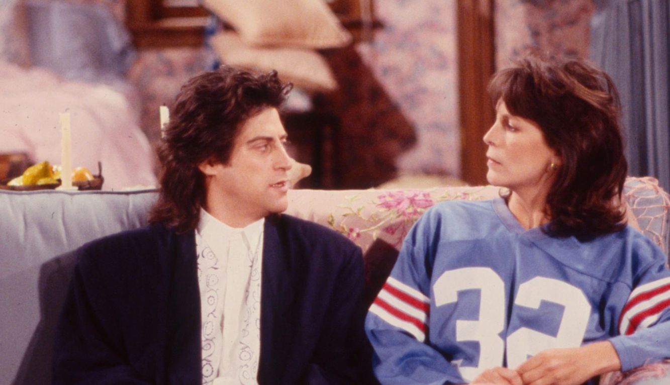 Richard Lewis and Jamie Lee Curtis sitting on a couch in the television series "Anything But Love."