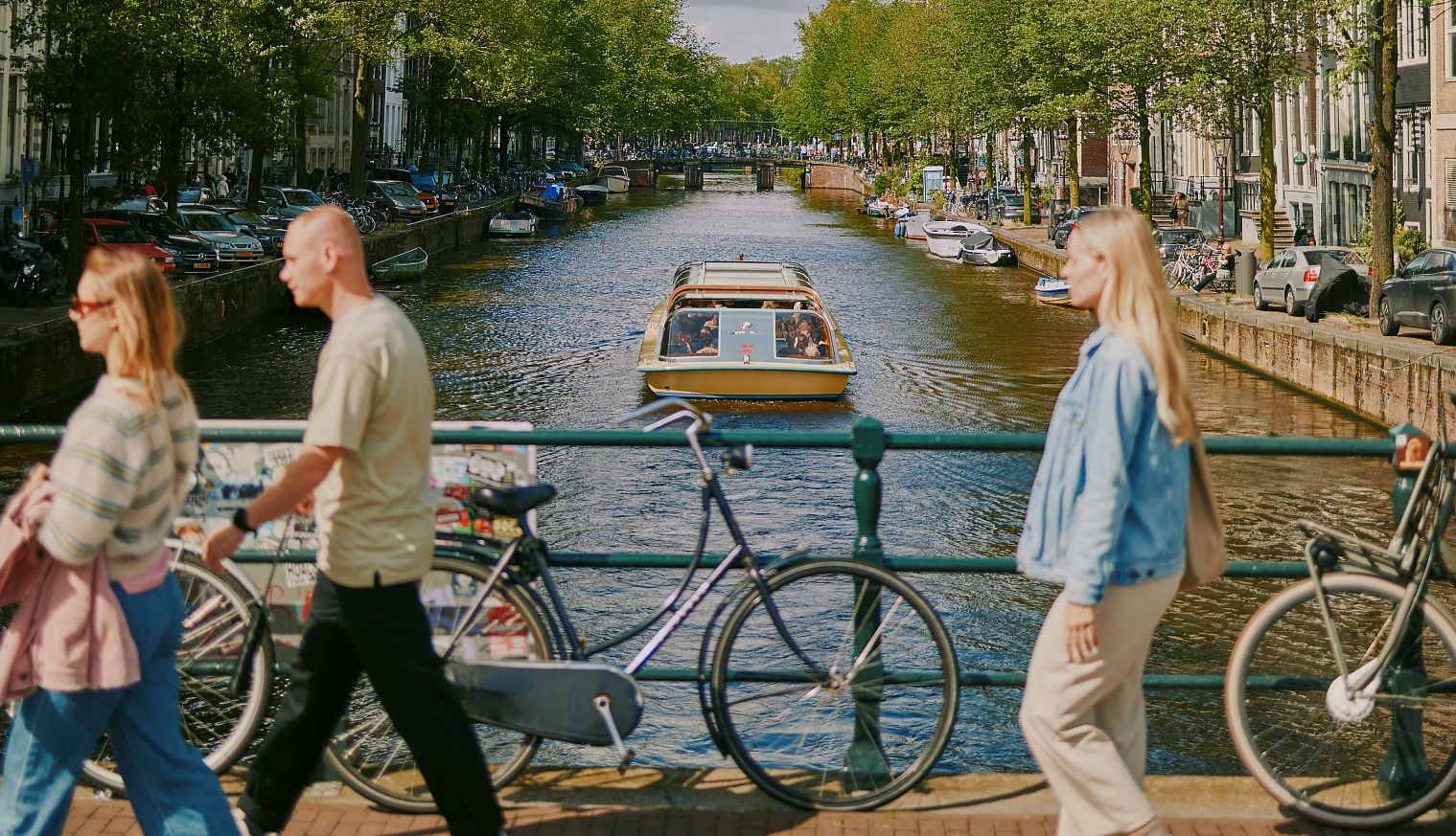 Amsterdam is very walkable people walking along the Herengracht Canal in Amsterdam